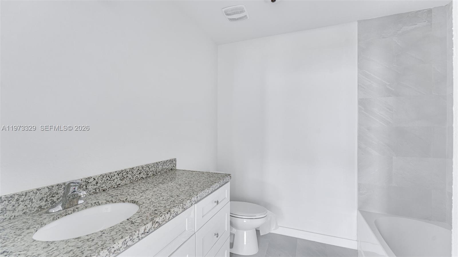 13375 Southwest 250th Street, Unit 104 Homestead, FL 33032 - Photo 15 of 27 a bathroom with a granite countertop sink and a mirror