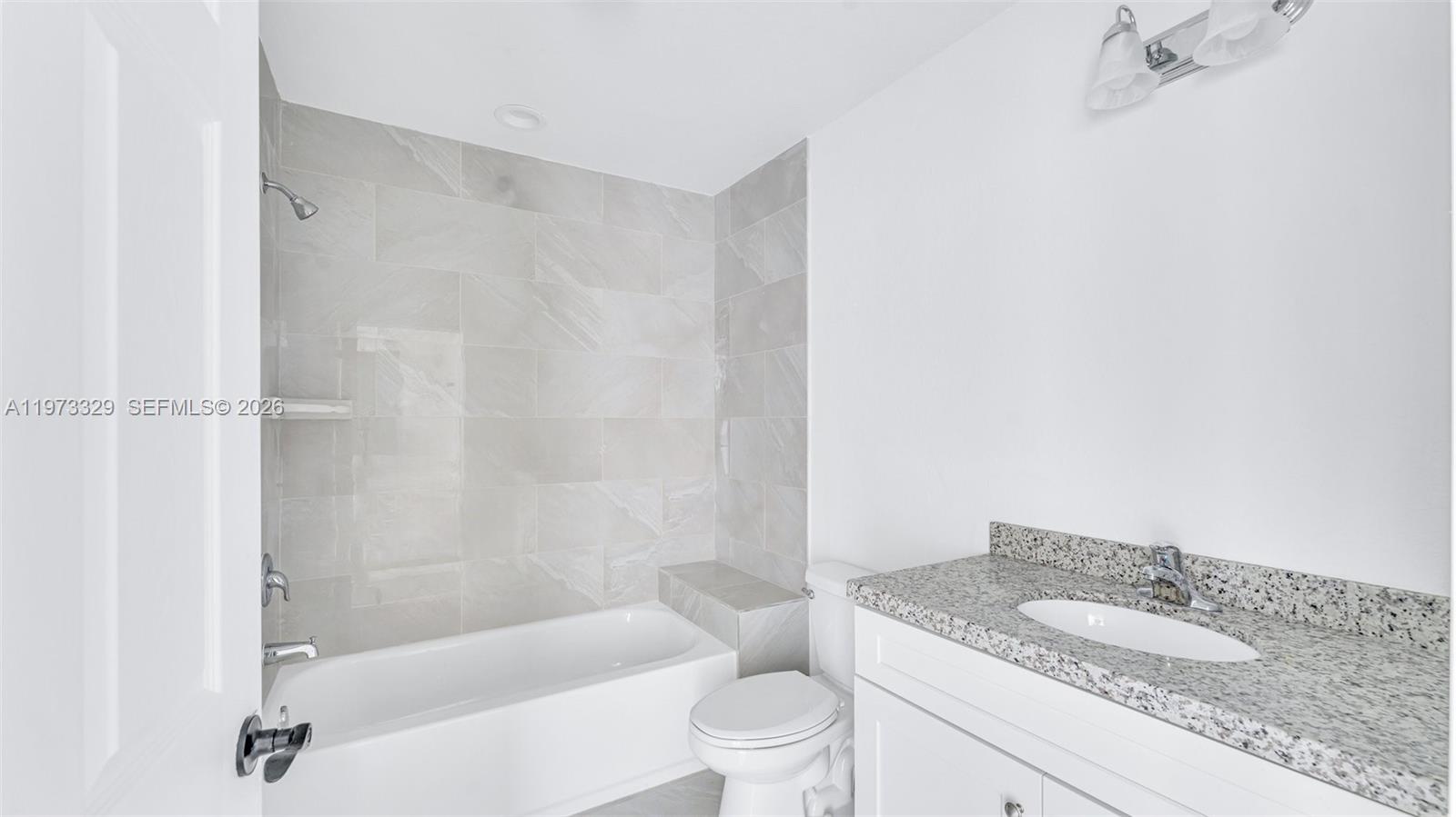 13375 Southwest 250th Street, Unit 104 Homestead, FL 33032 - Photo 22 of 27 a bathroom with a granite countertop bathtub shower sink vanity and toilet