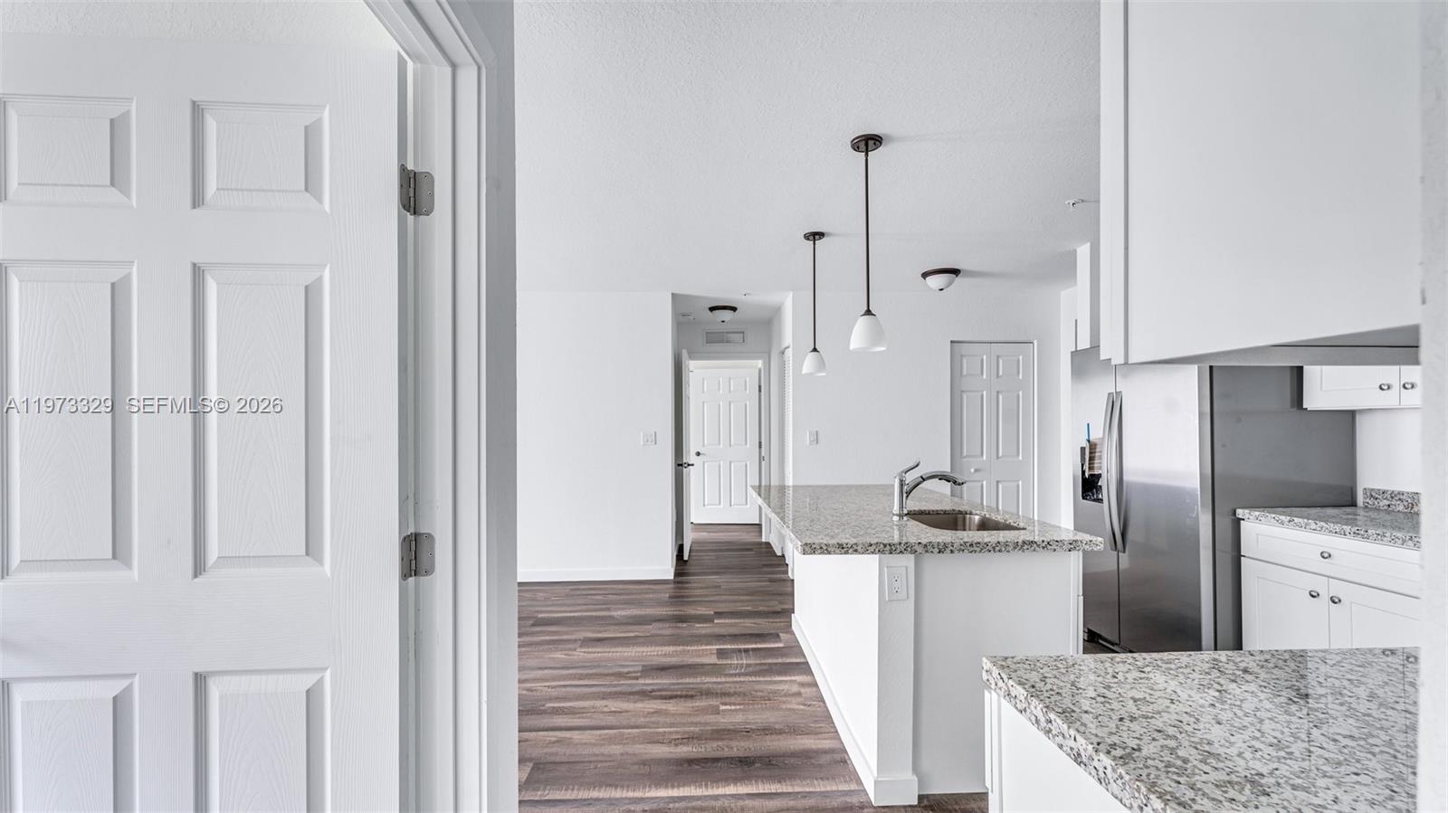 13375 Southwest 250th Street, Unit 104 Homestead, FL 33032 - Photo 23 of 27 a kitchen with stainless steel appliances granite countertop a refrigerator and a sink