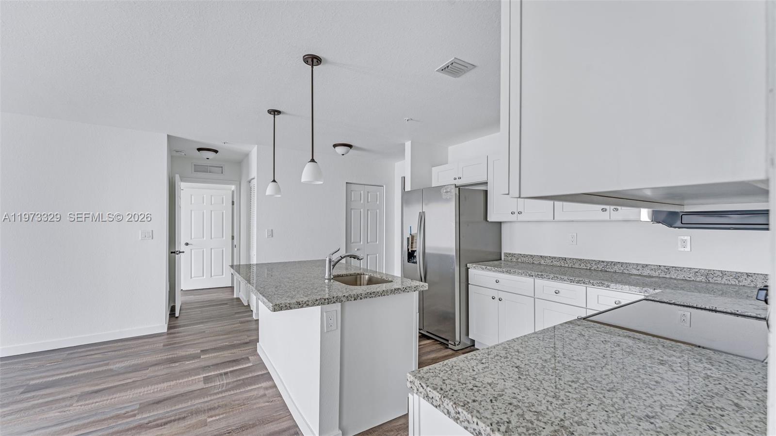 13375 Southwest 250th Street, Unit 104 Homestead, FL 33032 - Photo 24 of 27 a kitchen with a sink refrigerator and cabinets