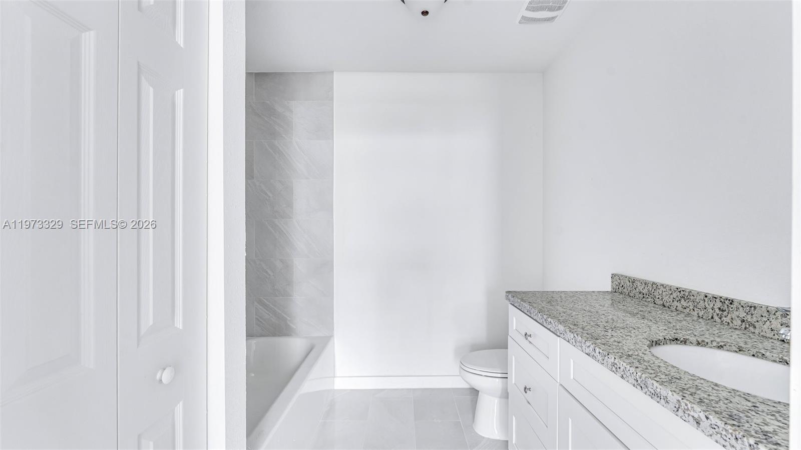 13375 Southwest 250th Street, Unit 104 Homestead, FL 33032 - Photo 27 of 27 a bathroom with a granite countertop sink and a toilet