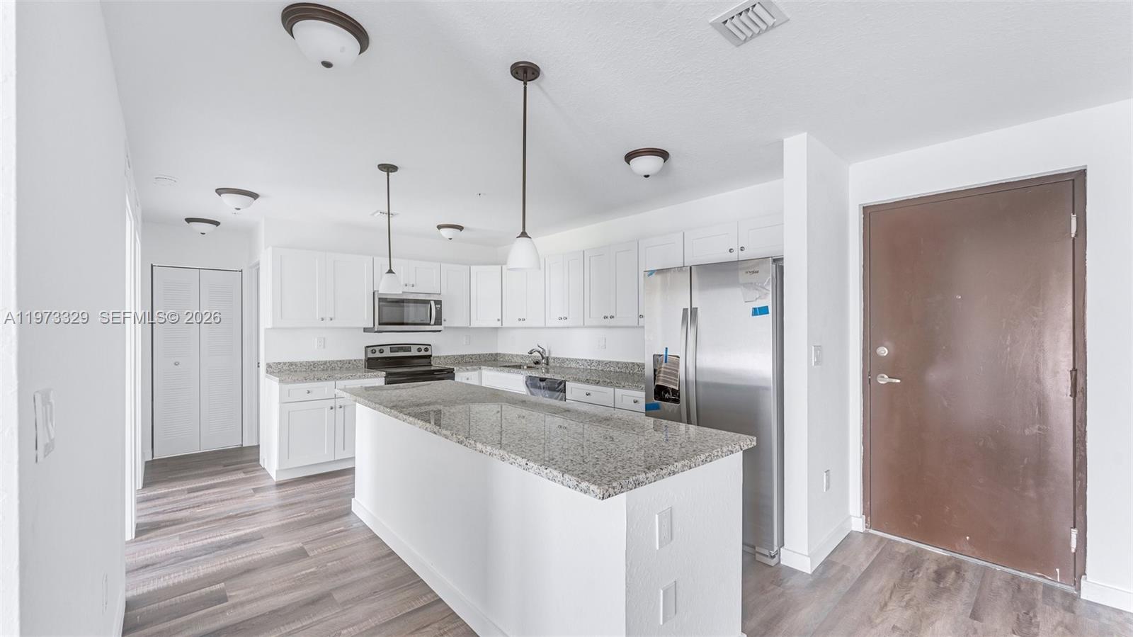 13375 Southwest 250th Street, Unit 104 Homestead, FL 33032 - Photo 3 of 27 a kitchen with stainless steel appliances granite countertop a sink a stove and a refrigerator