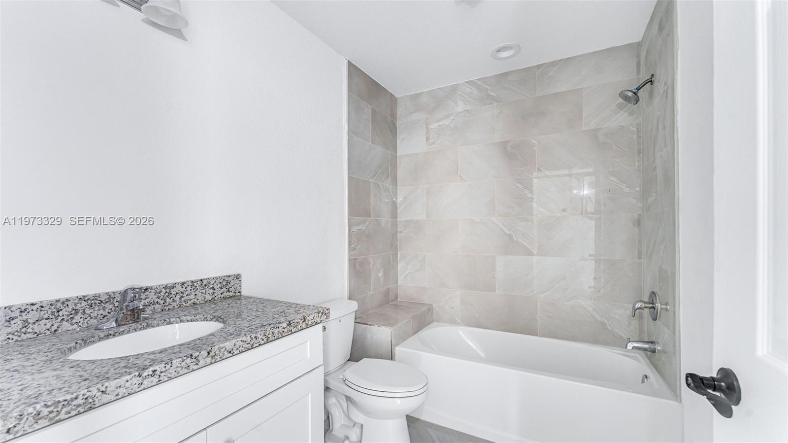 13375 Southwest 250th Street, Unit 104 Homestead, FL 33032 - Photo 7 of 27 a bathroom with a granite countertop sink a toilet and shower