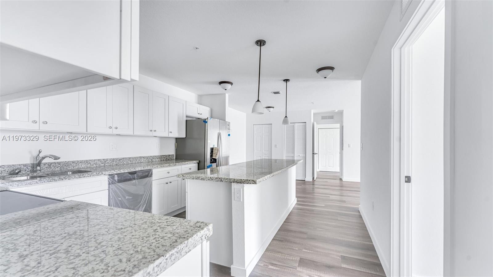 13375 Southwest 250th Street, Unit 104 Homestead, FL 33032 - Photo 8 of 27 a kitchen with stainless steel appliances granite countertop a sink stove and refrigerator