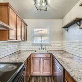 a kitchen with granite countertop cabinets stainless steel appliances and a counter space