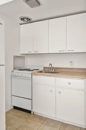 a kitchen with granite countertop white cabinets and white appliances