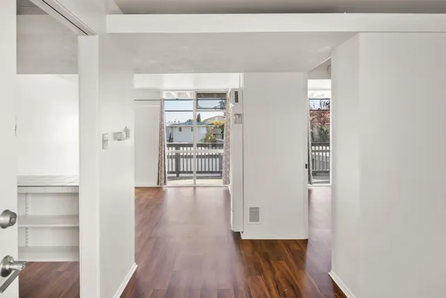 a view of a hallway with wooden floor and closet