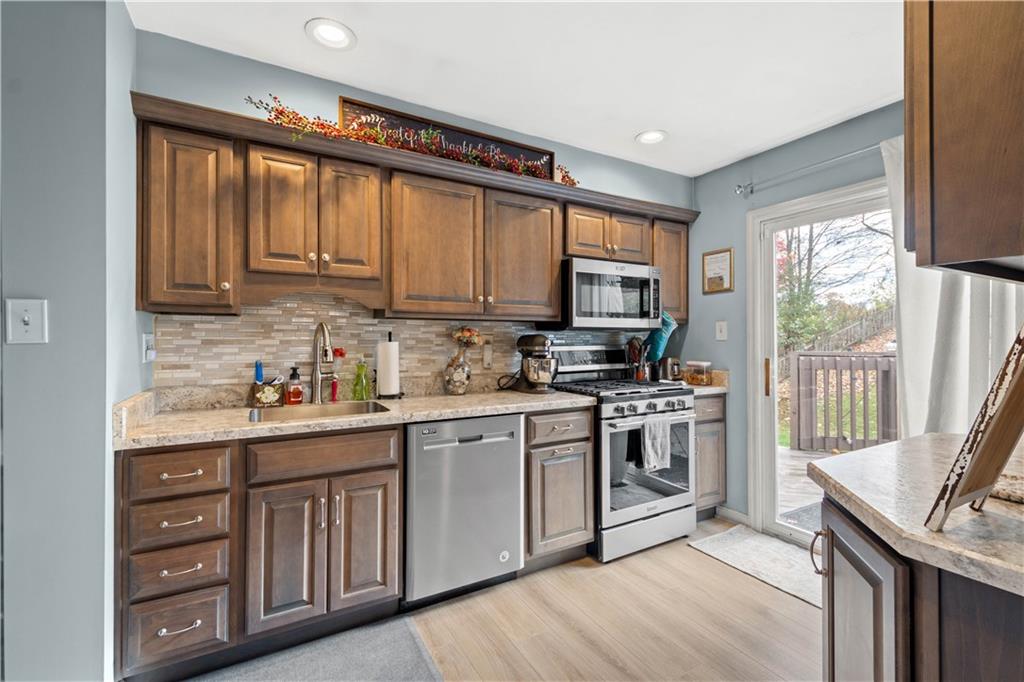 307 Lawrence Place Coraopolis, PA 15108 - Photo 12 of 25 a kitchen with stainless steel appliances granite countertop a stove a sink dishwasher and a microwave oven with cabinets