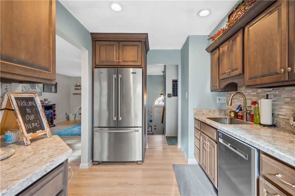 307 Lawrence Place Coraopolis, PA 15108 - Photo 14 of 25 a kitchen with granite countertop a refrigerator a sink a stove and wooden cabinets