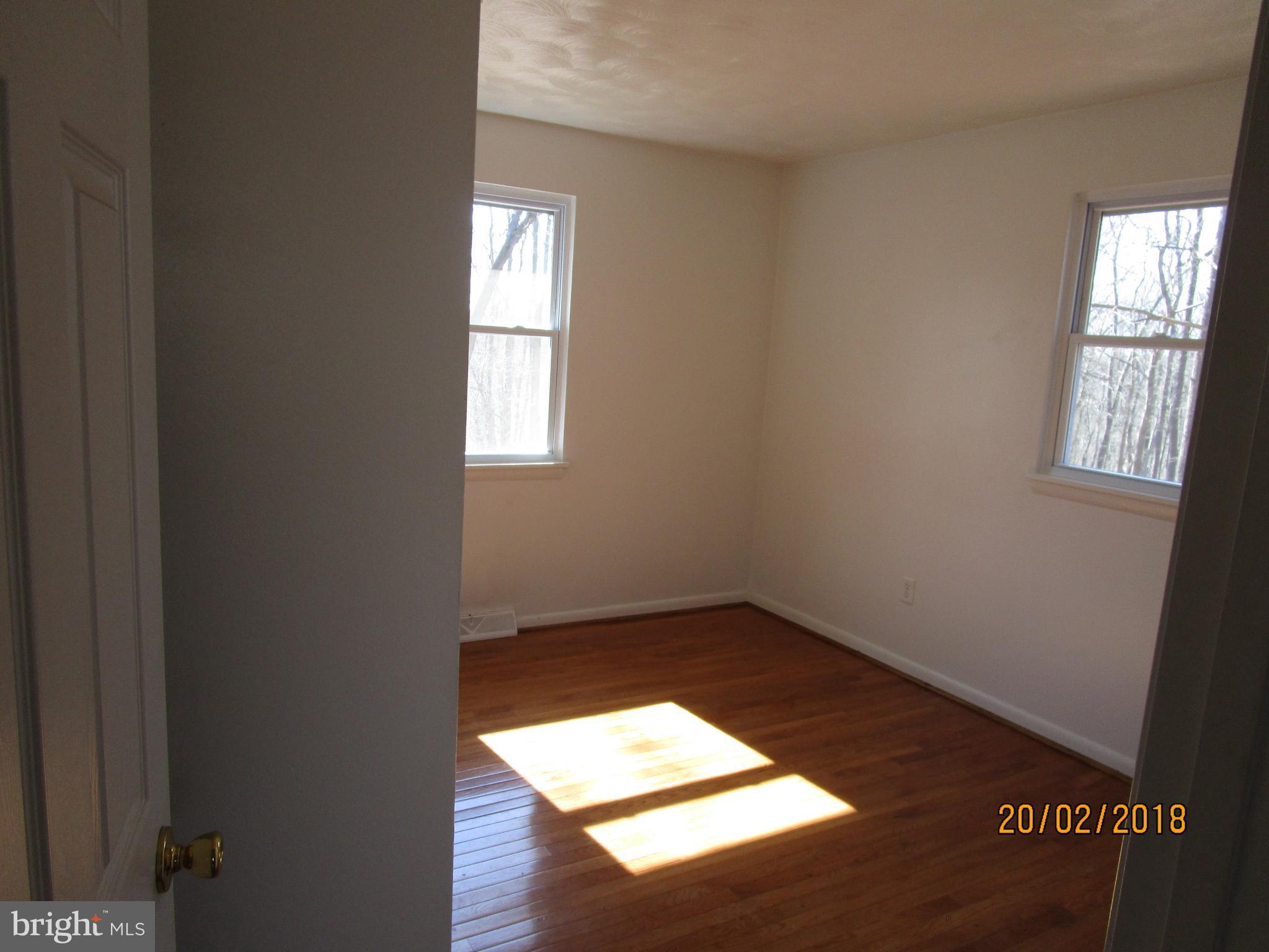 3534 Arters Mill Road Westminster, MD 21158 - Photo 6 of 13 an empty room with wooden floor and windows