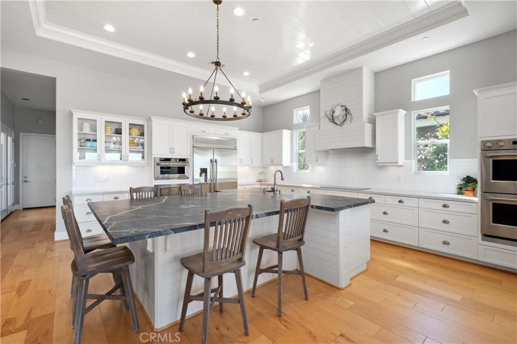 1594 Eucalyptus Road Nipomo, CA 93444 - Photo 12 of 75 a kitchen with stainless steel appliances kitchen island granite countertop a dining table chairs and chandelier