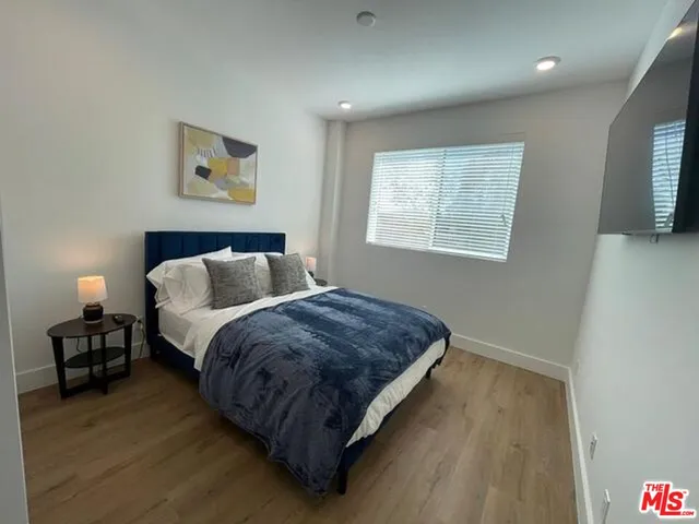 a spacious bedroom with a bed and wooden floor