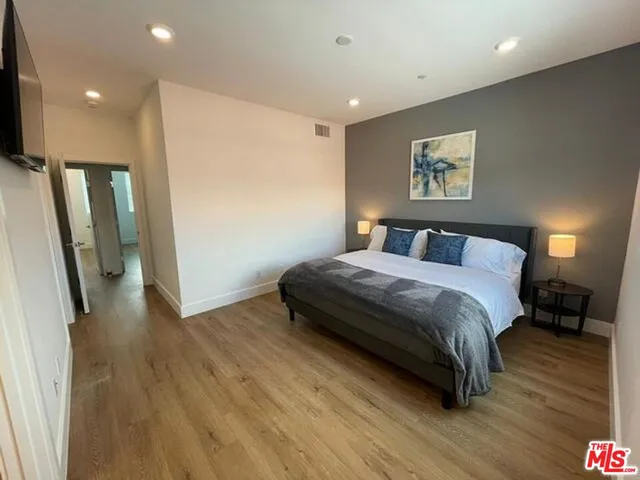 a bedroom with a bed and a flat screen tv