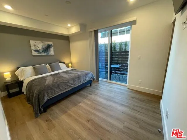 a bedroom with a large bed and a wooden floor