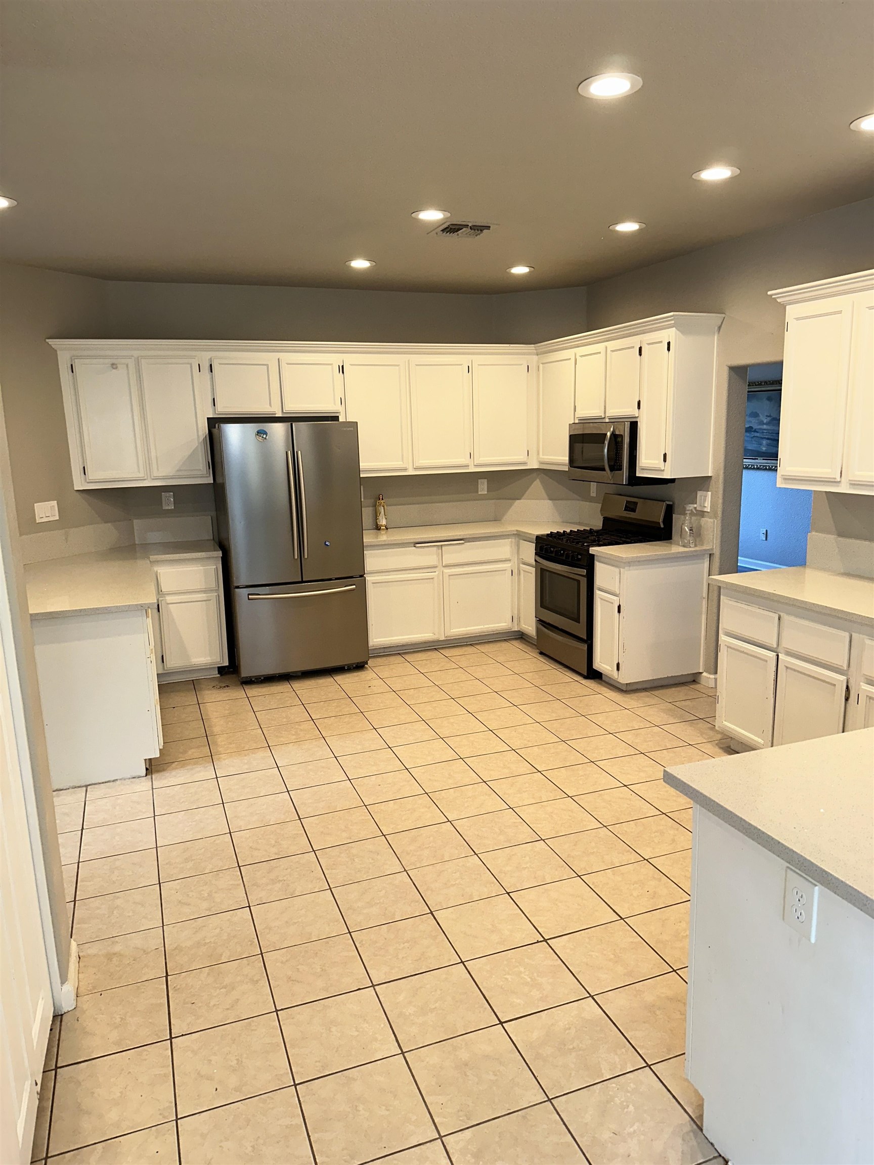 756 Rubier Way Rio Vista, CA 94571 - Photo 11 of 11 Kitchen with white cabinetry, stainless steel appliances, recessed lighting, light tile patterned floors, and light stone counters