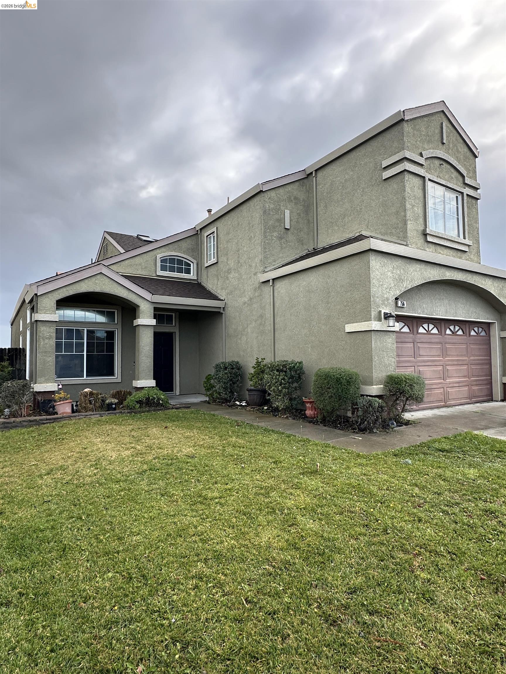 756 Rubier Way Rio Vista, CA 94571 - Photo 2 of 11 Traditional-style home featuring a front lawn, stucco siding, an attached garage, and concrete driveway