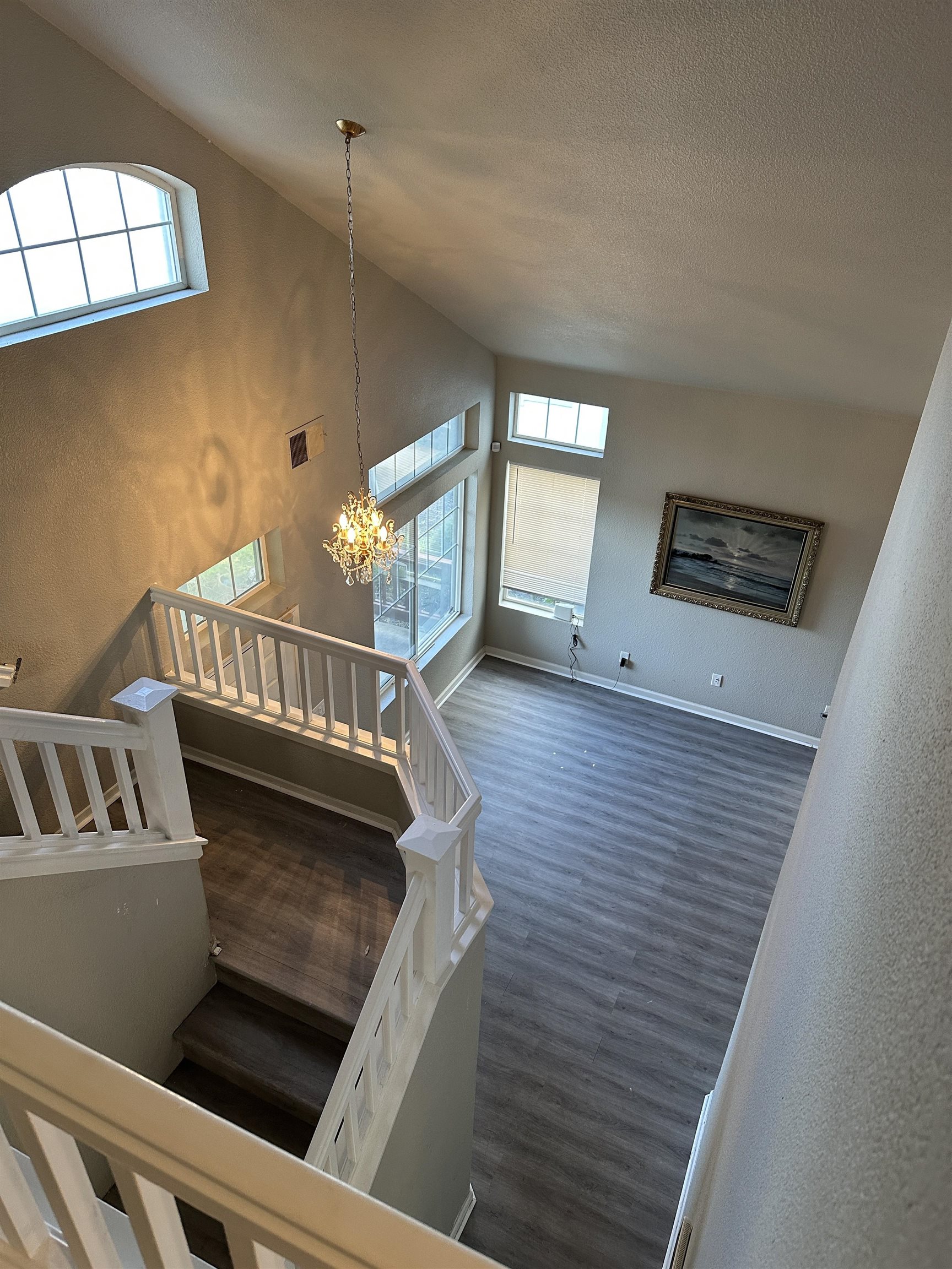 756 Rubier Way Rio Vista, CA 94571 - Photo 7 of 11 Stairway with a textured wall, a chandelier, wood finished floors, and a high textured ceiling