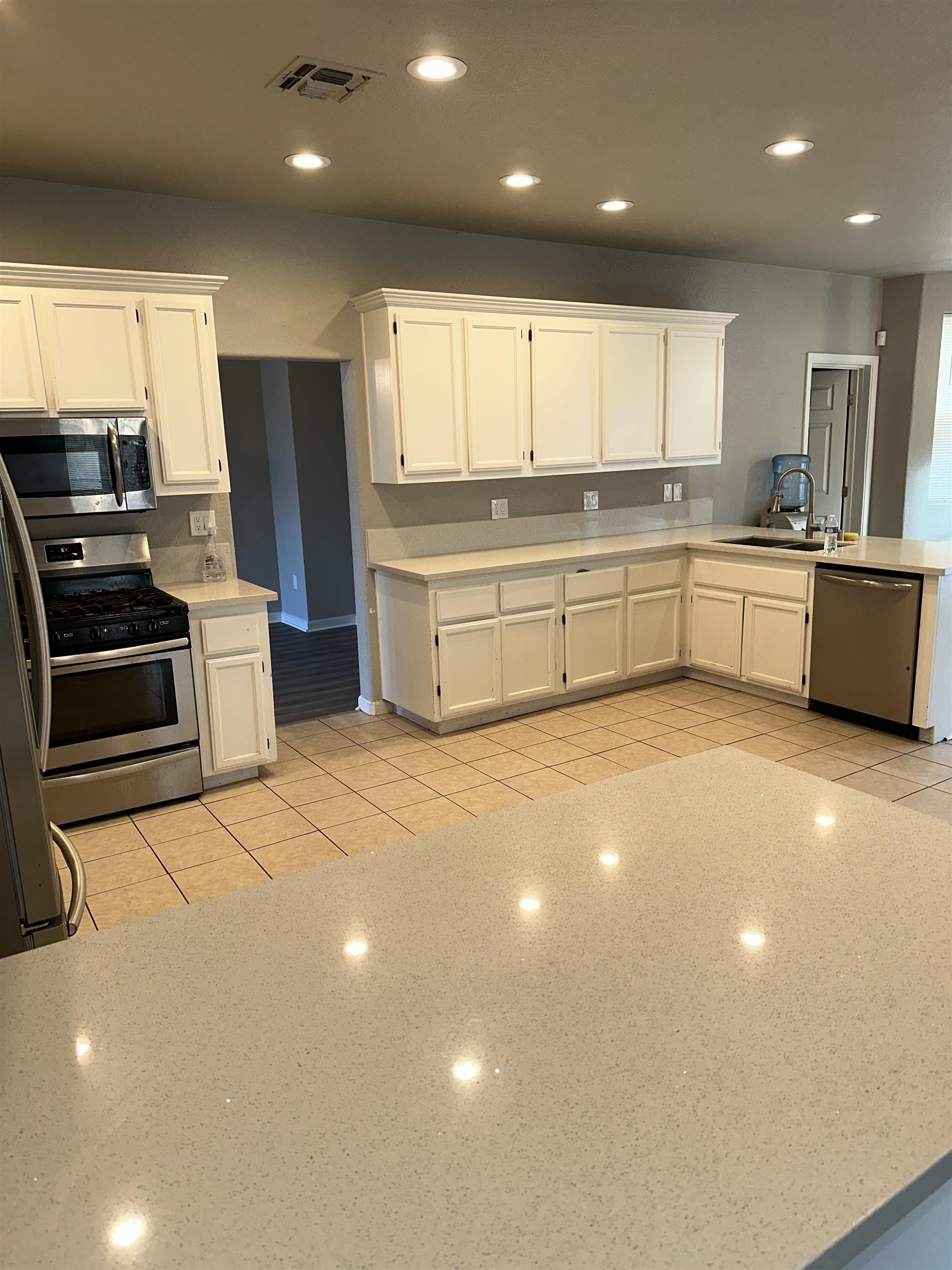 756 Rubier Way Rio Vista, CA 94571 - Photo 10 of 11 Kitchen with white cabinets, recessed lighting, a peninsula, stainless steel appliances, and light stone counters