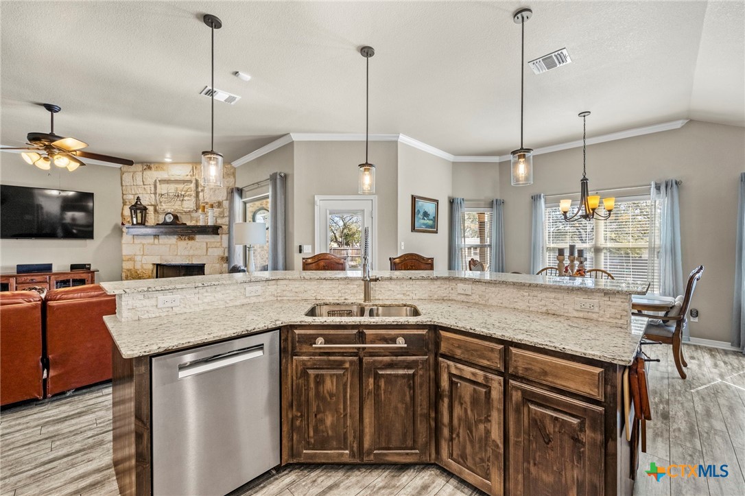 166 Mountain Rose Road Belton, TX 76513 - Photo 11 of 37 a kitchen with stainless steel appliances granite countertop a sink a stove and a wooden floor