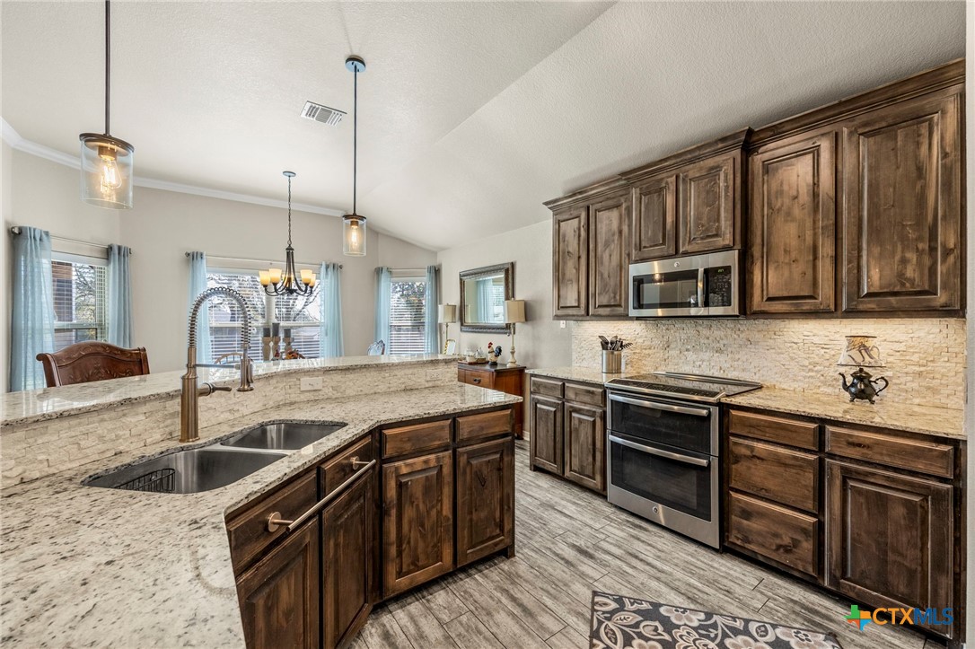 166 Mountain Rose Road Belton, TX 76513 - Photo 12 of 37 a kitchen with stainless steel appliances granite countertop a sink and a stove