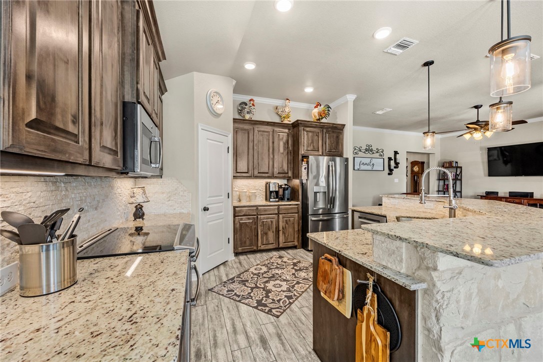 166 Mountain Rose Road Belton, TX 76513 - Photo 13 of 37 a kitchen with stainless steel appliances granite countertop a sink a stove and a refrigerator