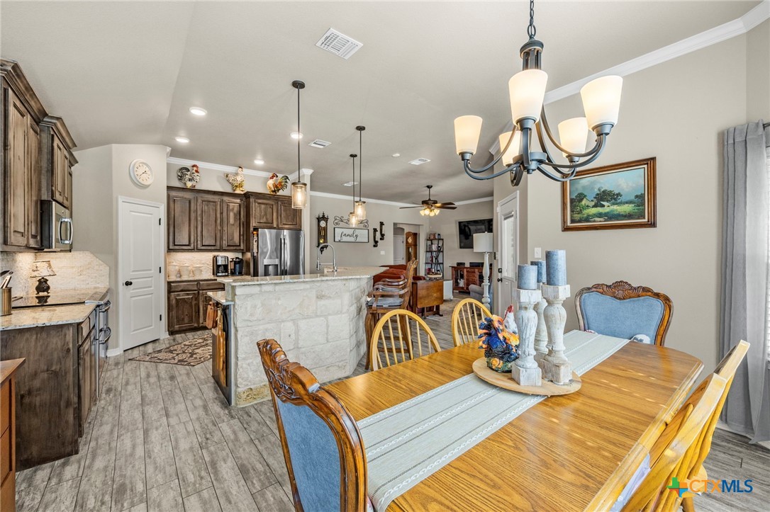 166 Mountain Rose Road Belton, TX 76513 - Photo 14 of 37 a view of a dining room and livingroom with furniture wooden floor a chandelier