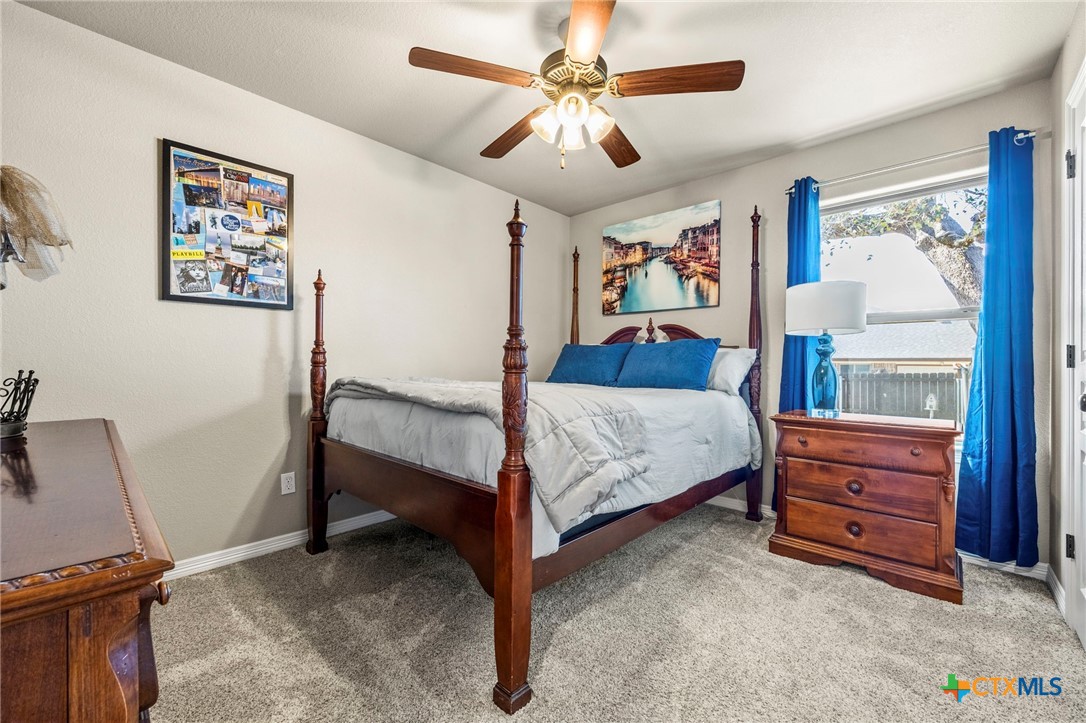 166 Mountain Rose Road Belton, TX 76513 - Photo 23 of 37 a bedroom with a bed and a chandelier