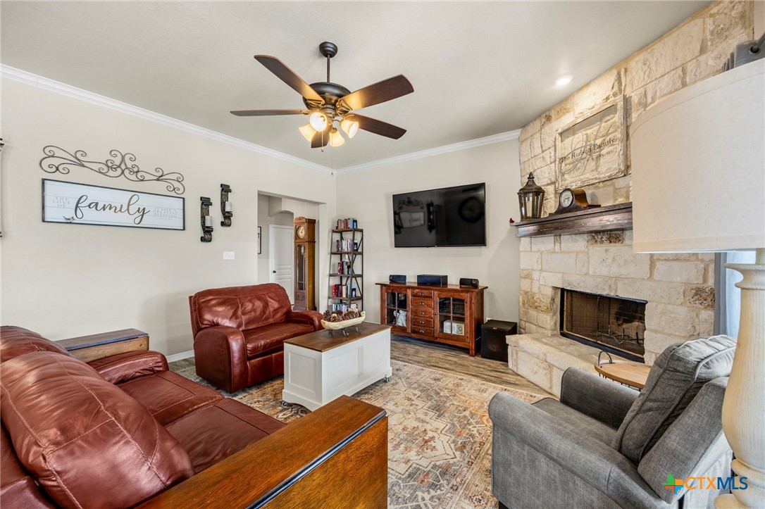 166 Mountain Rose Road Belton, TX 76513 - Photo 8 of 37 a living room with furniture a flat screen tv and a fireplace