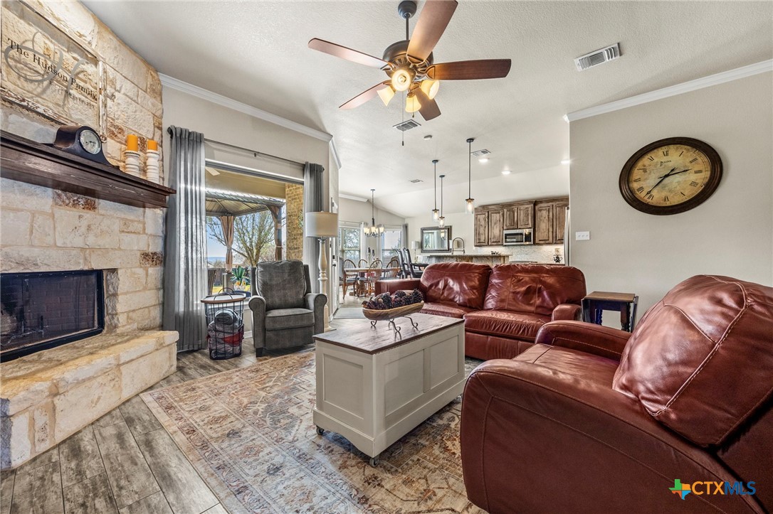 166 Mountain Rose Road Belton, TX 76513 - Photo 9 of 37 a living room with furniture a clock and a fireplace