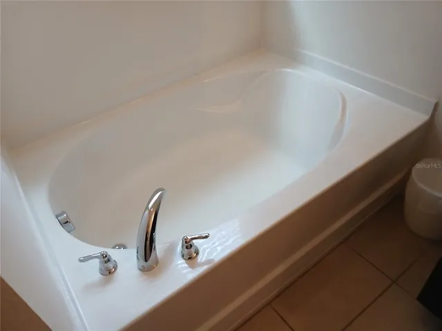a view of a patio with a table chairs and a tub