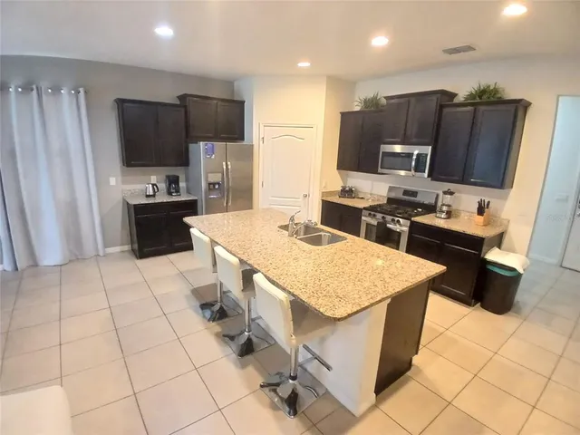 a kitchen with stainless steel appliances granite countertop a sink stove and refrigerator