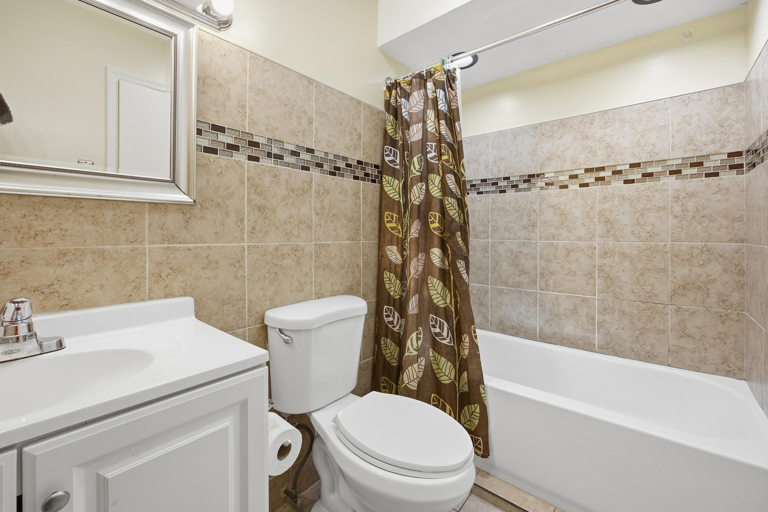 1102 Southeast Petunia Avenue Port St. Lucie, FL 34952 - Photo 11 of 23 a bathroom with a sink a toilet and a bathtub