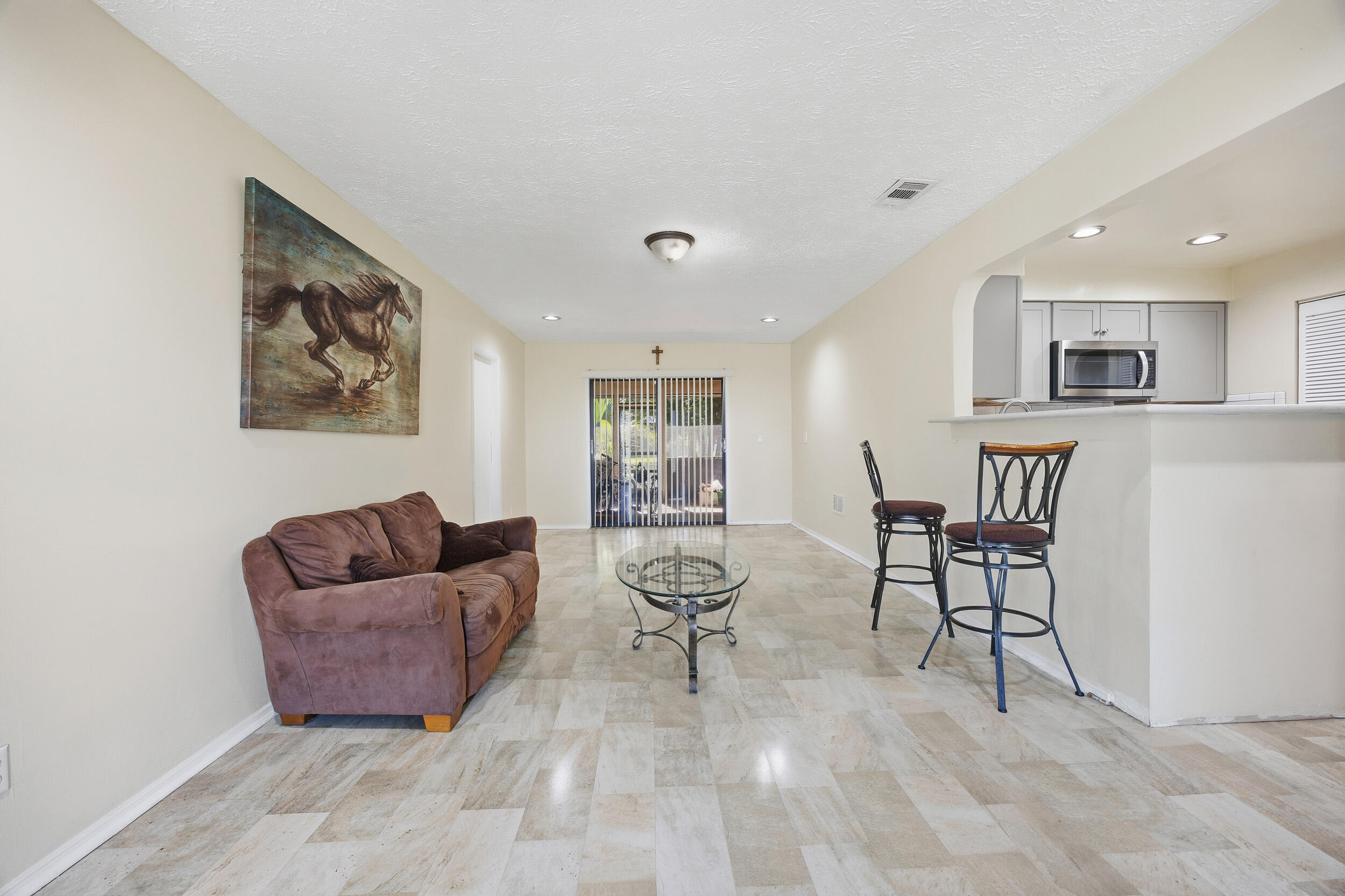 1102 Southeast Petunia Avenue Port St. Lucie, FL 34952 - Photo 3 of 23 a living room with furniture and a dining table with wooden floor