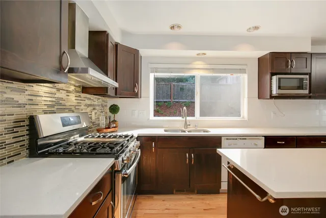 a kitchen with a stove a sink a microwave and a refrigerator