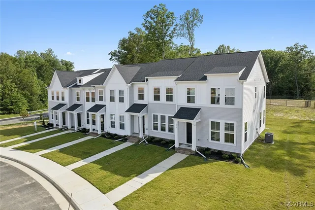 a view of a house with a big yard and large trees