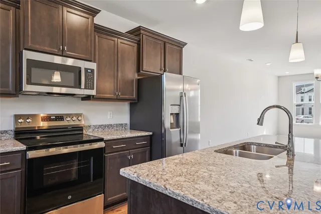 a kitchen with stainless steel appliances granite countertop a stove microwave and refrigerator