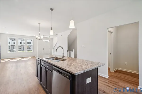 a kitchen that has a kitchen island wooden floor and a sink
