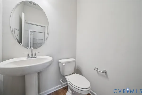 a bathroom with a toilet a sink and mirror