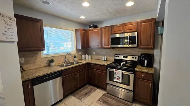 a kitchen with stainless steel appliances granite countertop a stove sink and microwave