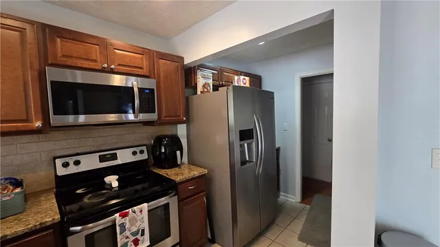 a kitchen with stainless steel appliances a stove a microwave and a refrigerator
