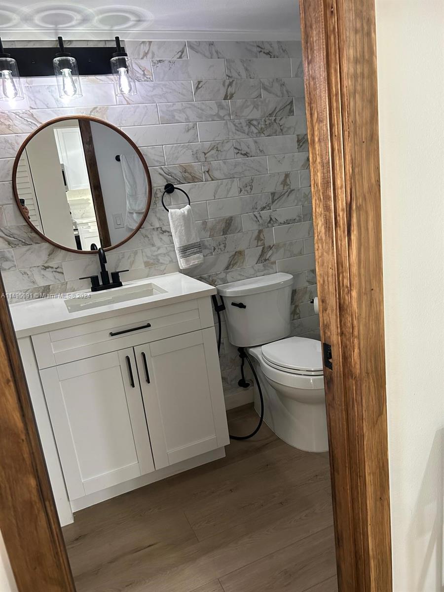 a bathroom with a toilet a sink and mirror