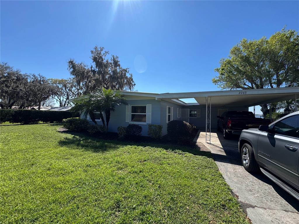2263 North Lake Reedy Boulevard Frostproof, FL 33843 - Photo 47 of 50 a front view of a house with garden and trees
