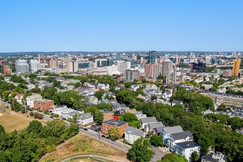 an aerial view of residential houses with outdoor space and trees