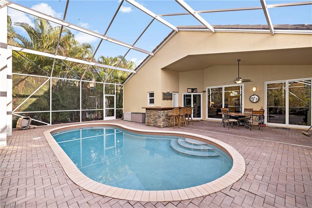 227 Glen Eagle Circle Naples, FL 34104 - Photo 1 of 25 a view of a swimming pool with outdoor seating