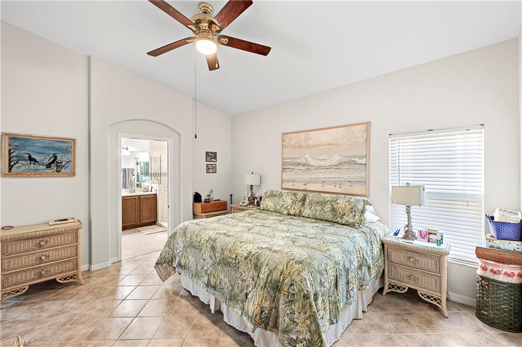 227 Glen Eagle Circle Naples, FL 34104 - Photo 13 of 25 a bedroom with a bed and a chandelier