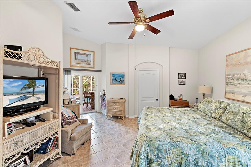 227 Glen Eagle Circle Naples, FL 34104 - Photo 15 of 25 a bedroom with a bed and a flat screen tv