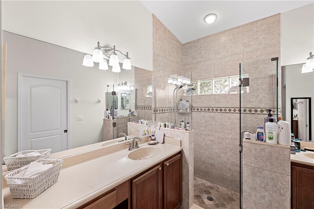 227 Glen Eagle Circle Naples, FL 34104 - Photo 17 of 25 a bathroom with a sink vanity granite and a mirror