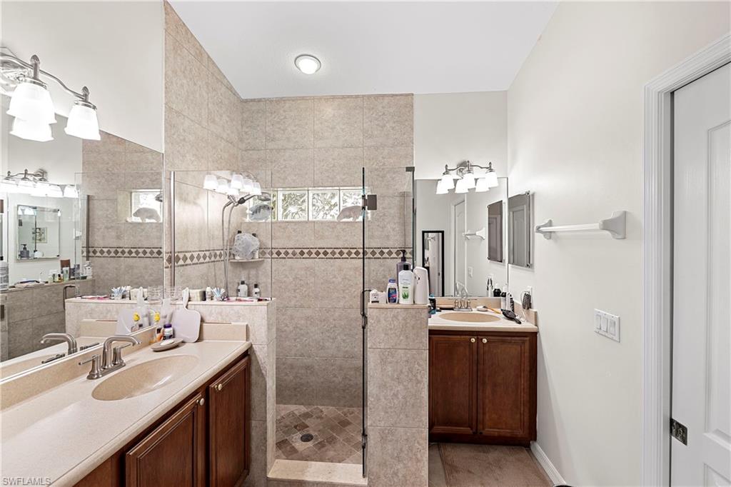 227 Glen Eagle Circle Naples, FL 34104 - Photo 18 of 25 a bathroom with a sink double vanity and shower