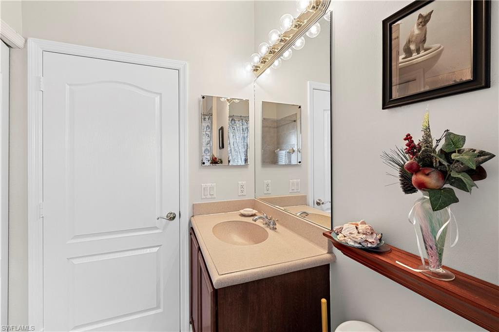 227 Glen Eagle Circle Naples, FL 34104 - Photo 22 of 25 a bathroom with a sink vanity and a mirror