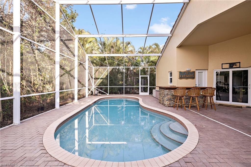 227 Glen Eagle Circle Naples, FL 34104 - Photo 23 of 25 a view of a swimming pool with outdoor seating